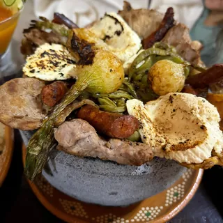 Molcajete con arrachera, chistorra, cebollitas cambray y queso asado
